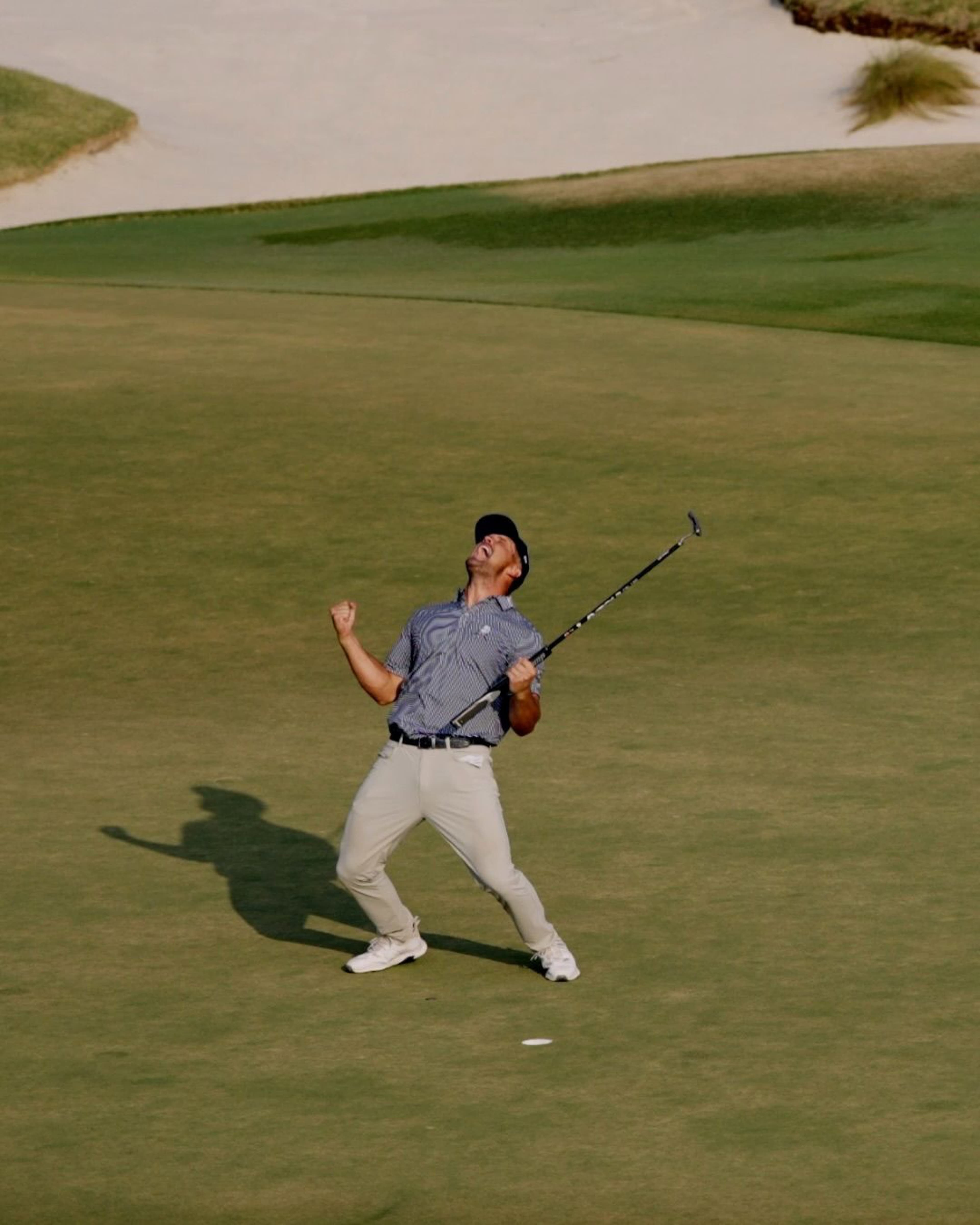 Golfer celebrating a winning shot on a golf green